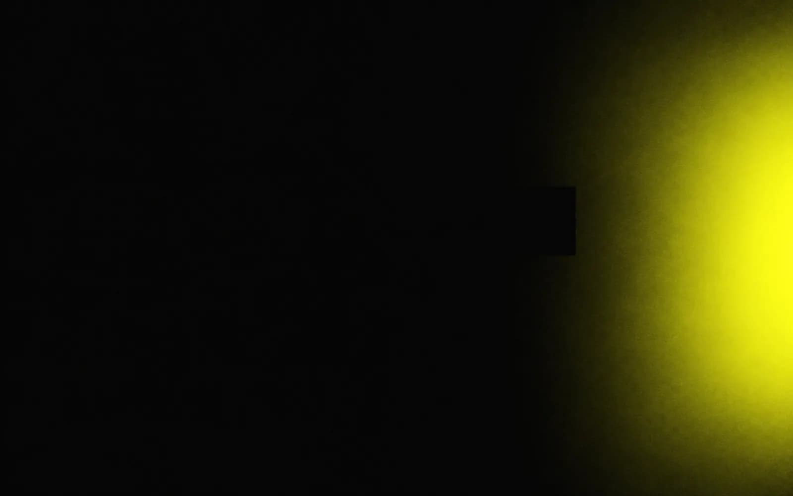 Yellow light emerging from darkness along the edge of a black frame, the first signal in the Diagnose phase