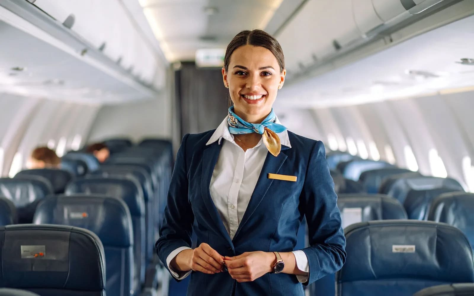 Smiling flight attendant standing in the aisle of an aircraft cabin